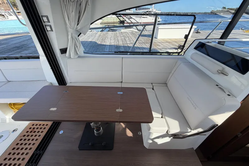 Slide: The Image of Interior of 2026 Beneteau Antares 11 Fly with elegant seating and wooden table. - 14