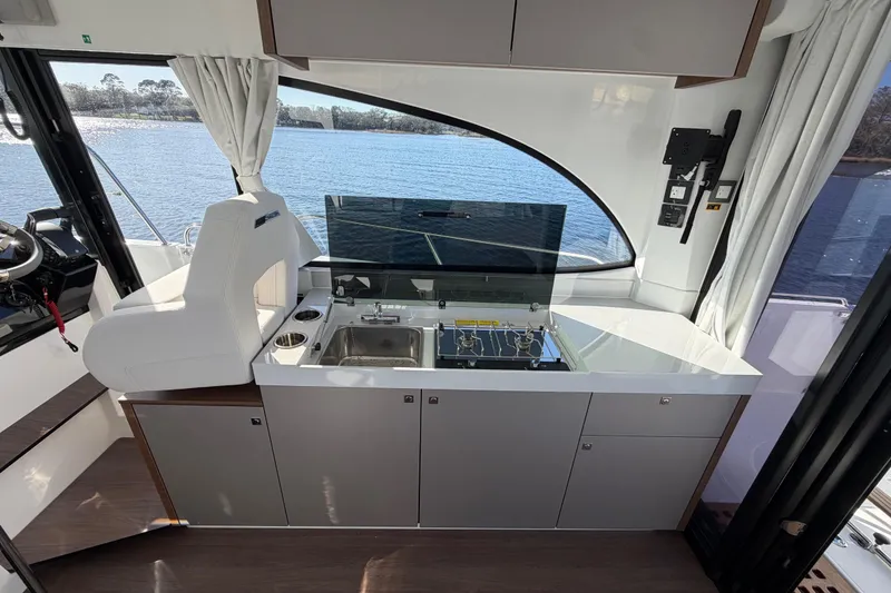 Slide: The Image of Interior of 2026 Beneteau Antares 11 Fly yacht with modern kitchenette and scenic water view. - 15