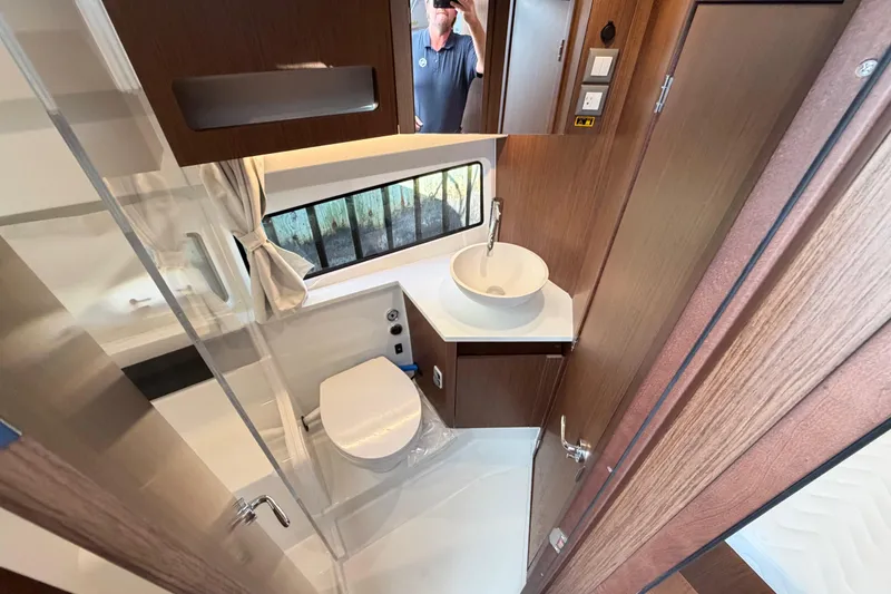 Slide: The Image of Bathroom interior of 2026 Beneteau Antares 11 Fly with modern fixtures and wood accents. - 19