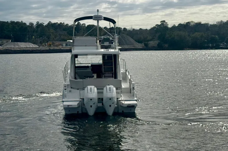 Slide: The Image of 2026 Beneteau Antares 11 Fly cruising on a serene lake under a cloudy sky. - 6