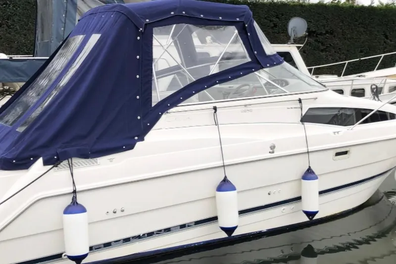The Image of 1998 Bayliner 2655 Ciera boat with blue canopy docked in marina. - 1