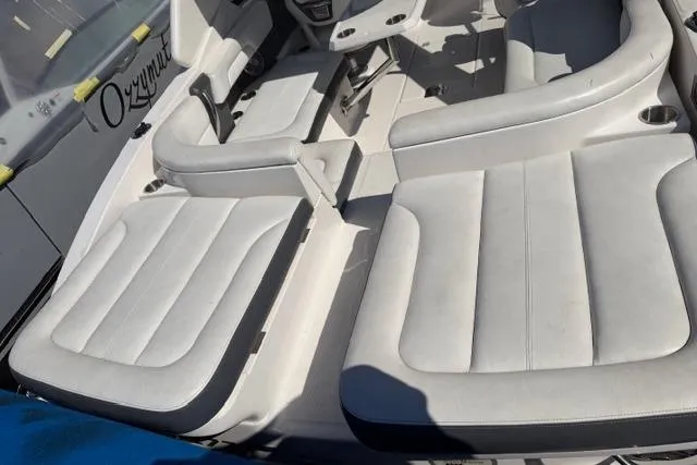 Slide: The Image of 2013 Chaparral 277 SSX boat interior with white cushioned seating and cup holders. - 12