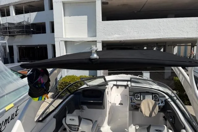 Slide: The Image of 2013 Chaparral 277 SSX boat interior with dashboard and seating, docked near a building. - 13