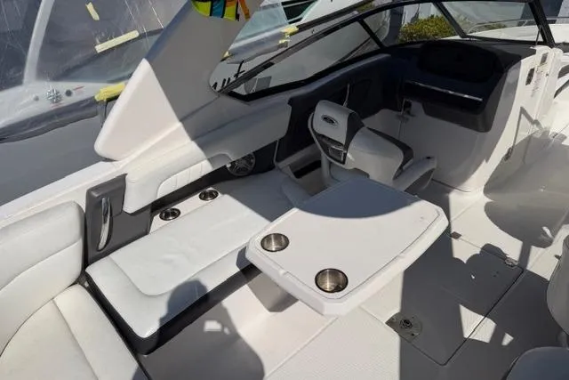 Slide: The Image of Interior of a 2013 Chaparral 277 SSX boat featuring white seating and a table with cup holders. - 8