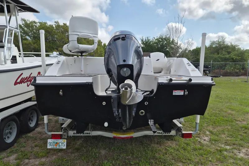 Slide: The Image of 2023 Starcraft SVX 171 OB boat, rear view with outboard motor, parked on grass. - 3