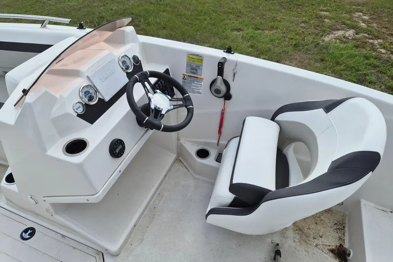 Slide: The Image of 2023 Starcraft SVX 171 OB boat cockpit with steering wheel and comfortable seating. - 7