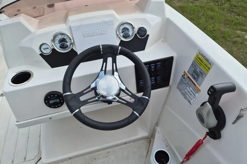 Slide: The Image of 2023 Starcraft SVX 171 OB boat dashboard with steering wheel and control panel. - 8