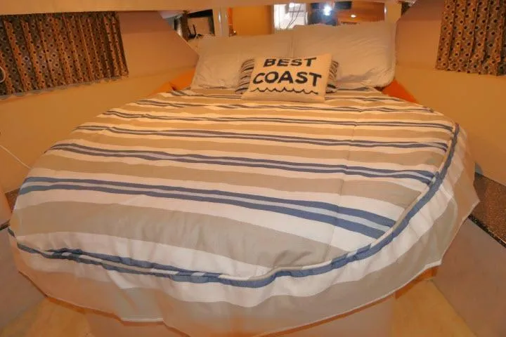 Slide: The Image of Cozy bedroom in 2003 Thunderbird Formula 40PC yacht with striped bedding and "Best Coast" pillow. - 12