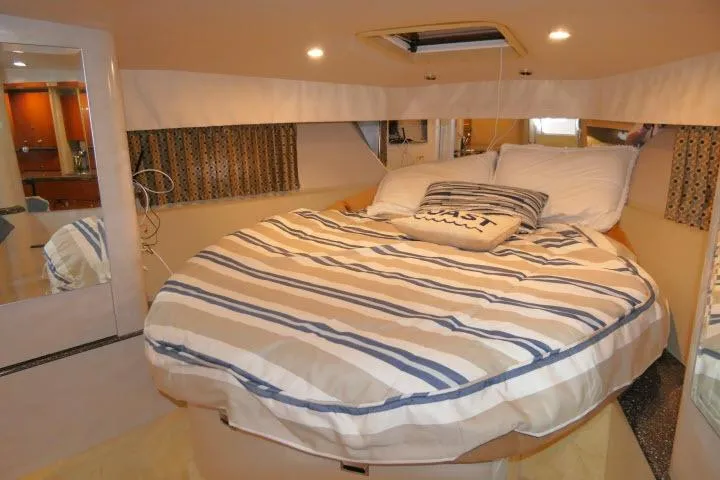Slide: The Image of Cozy cabin interior of 2003 Thunderbird Formula 40PC with striped bedding and nautical decor. - 13