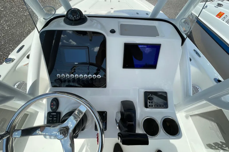 Slide: The Image of 2023 Sea Pro 208 Bay boat dashboard with steering wheel and navigation controls. - 6