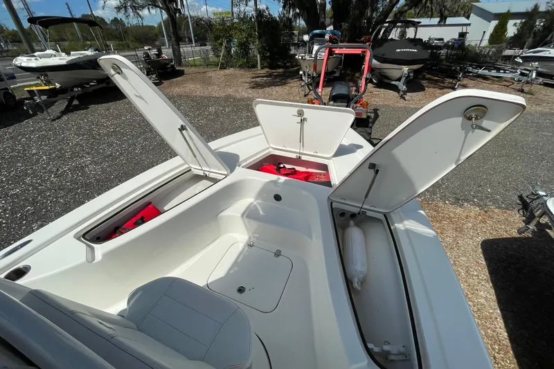 Slide: The Image of 2023 Sea Pro 208 Bay boat with open storage compartments in a marina setting. - 8