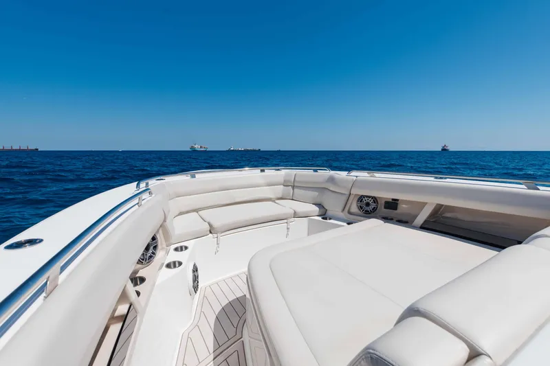 Slide: The Image of 2021 Boston Whaler 350 Realm interior with white seating and blue sky background. - 19