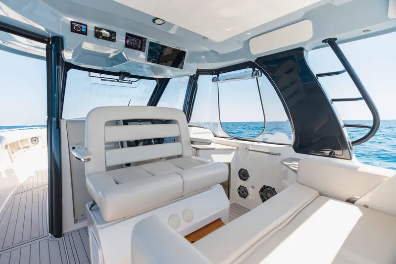 Slide: The Image of Interior of 2021 Boston Whaler 350 Realm with white seating and mounted TV. - 28