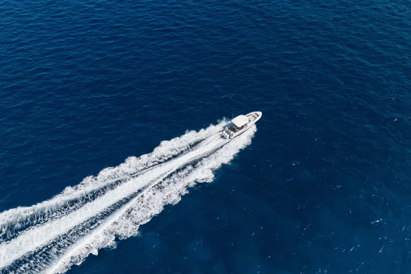 Slide: The Image of 2021 Boston Whaler 350 Realm cruising on clear blue ocean waters. - 3