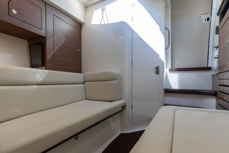 Slide: The Image of 2021 Boston Whaler 350 Realm boat bathroom with sink, toilet, and wooden accents. - 33