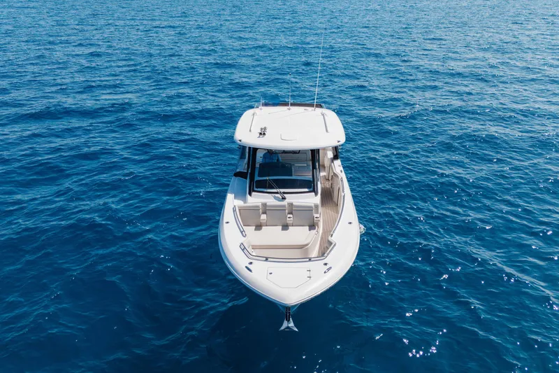 Slide: The Image of 2021 Boston Whaler 350 Realm with triple Mercury engines on blue ocean water. - 6