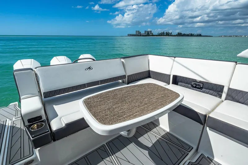 Slide: The Image of 2023 Monterey 350 Sport Yacht interior with seating and table, overlooking serene ocean view. - 12