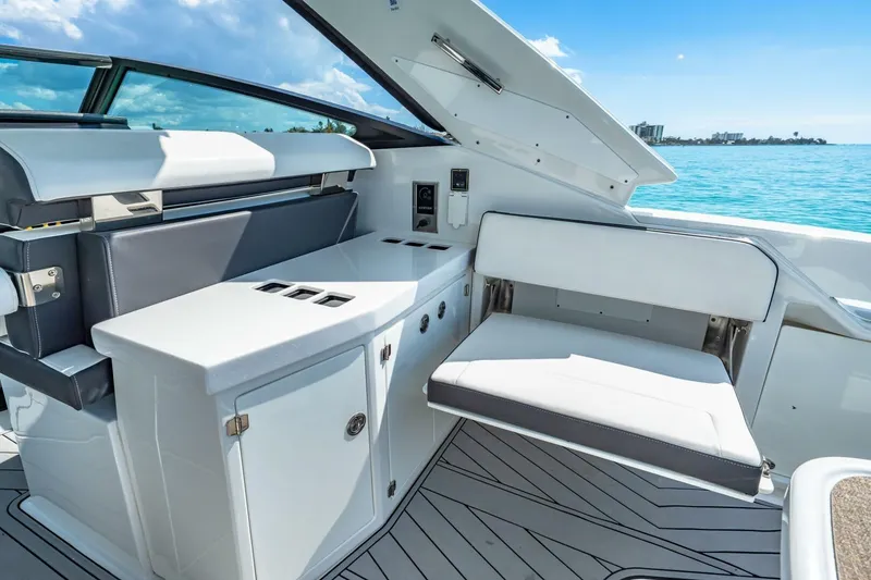 Slide: The Image of 2023 Monterey 350 Sport Yacht interior with sleek seating and cabinetry, overlooking serene blue waters. - 13