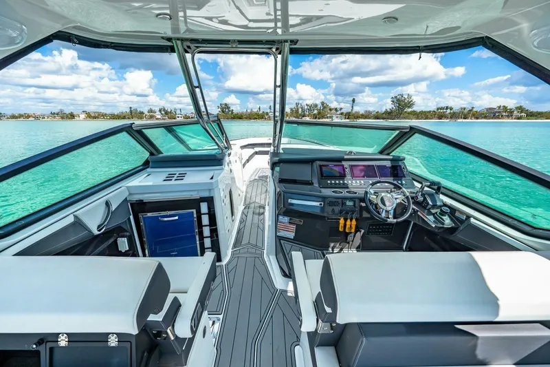 Slide: The Image of 2023 Monterey 350 Sport Yacht interior with modern helm and scenic water view. - 14