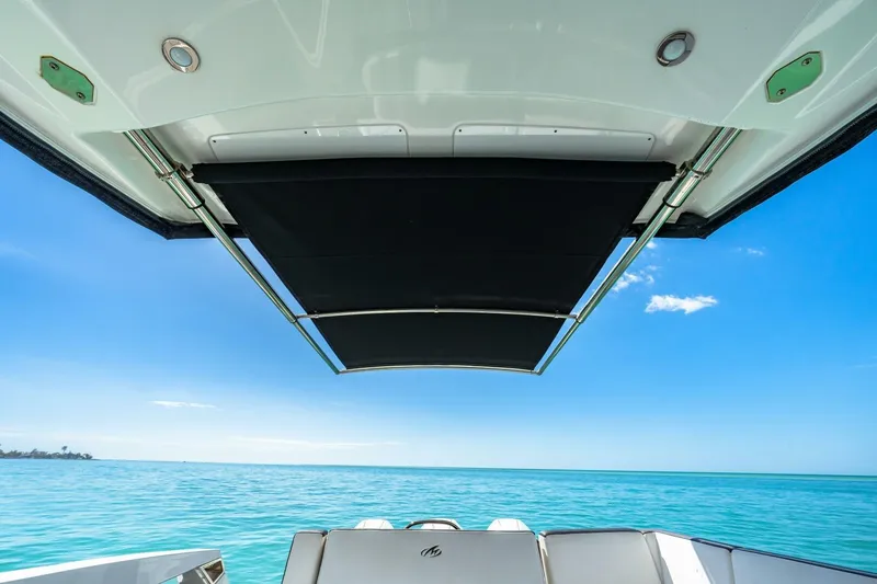Slide: The Image of 2023 Monterey 350 Sport Yacht with retractable sunshade on open sea. - 22
