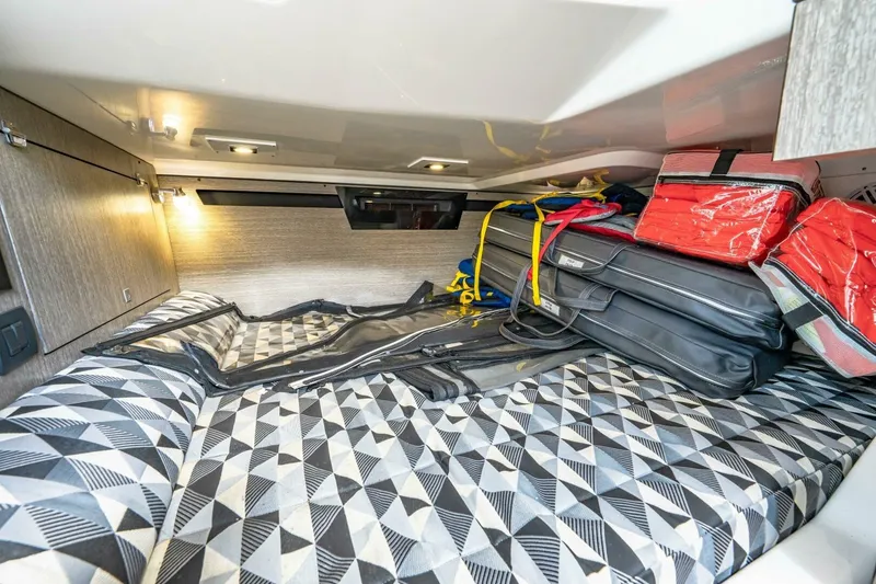 Slide: The Image of Cozy cabin storage in 2023 Monterey 350 Sport Yacht with geometric-patterned bedding. - 30