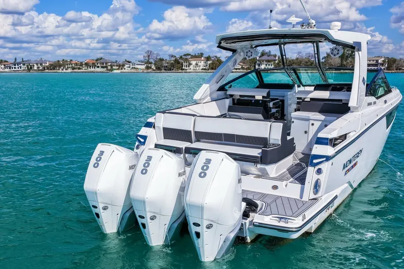 Slide: The Image of 2023 Monterey 350 Sport Yacht on turquoise water, featuring triple Mercury outboard engines. - 43