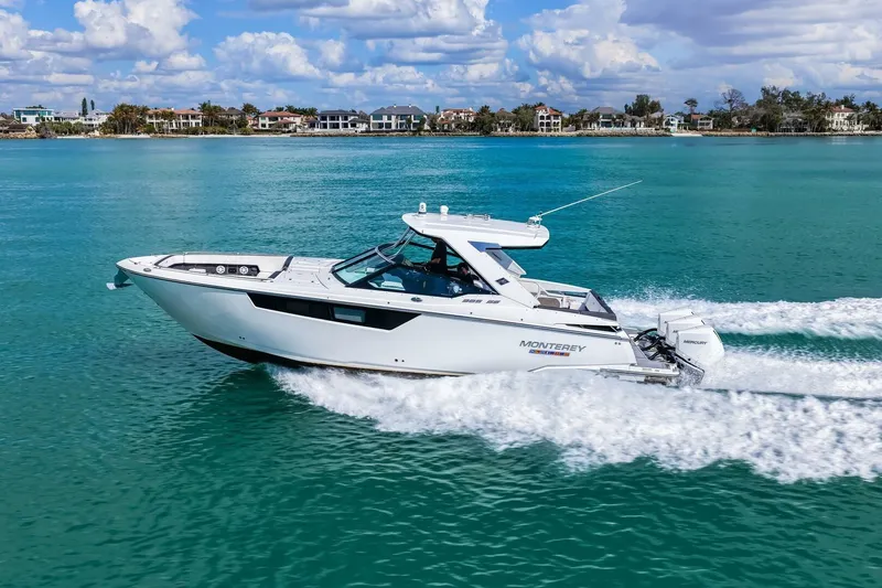 Slide: The Image of 2023 Monterey 350 Sport Yacht cruising on turquoise waters under a partly cloudy sky. - 52