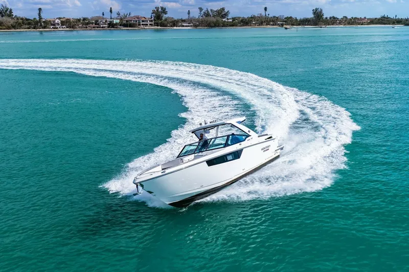 Slide: The Image of 2023 Monterey 350 Sport Yacht cruising on turquoise waters, leaving a wake trail. - 58
