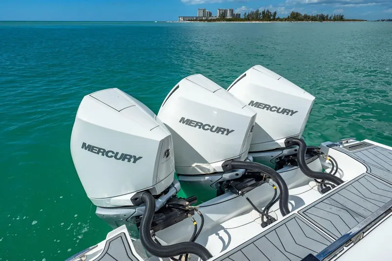 Slide: The Image of Triple Mercury outboard engines on a 2023 Monterey 350 Sport Yacht in clear blue waters. - 6