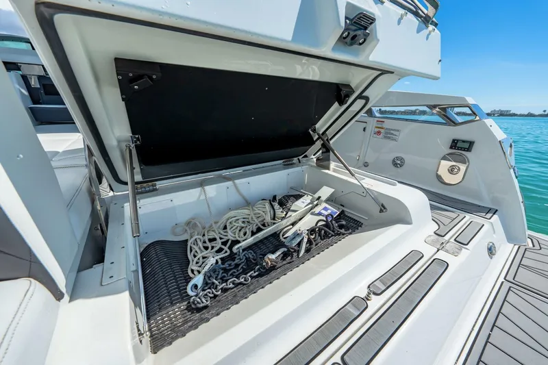 Slide: The Image of 2023 Monterey 350 Sport Yacht storage compartment with ropes and anchor, open on deck. - 8