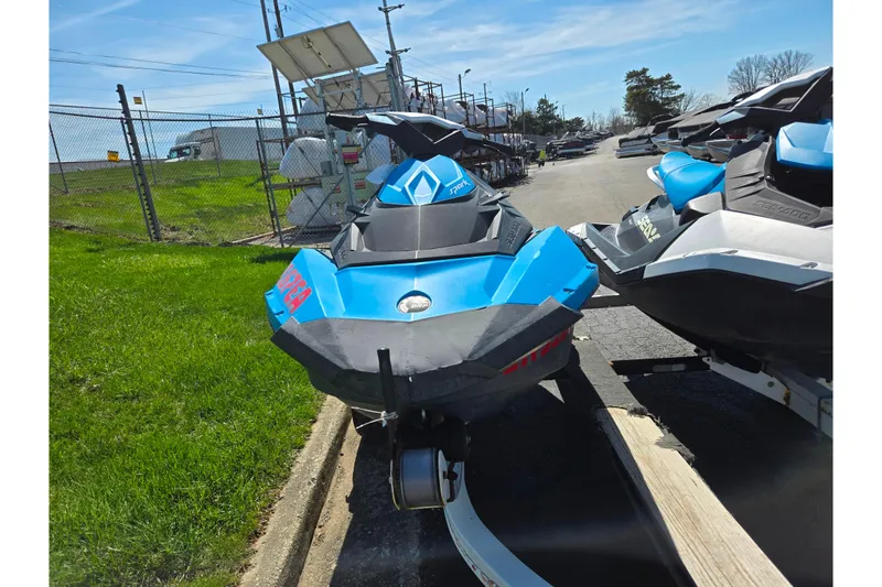 Slide: The Image of 2017 Sea-Doo Spark 2up jet ski in blue, parked on a trailer outdoors. - 6