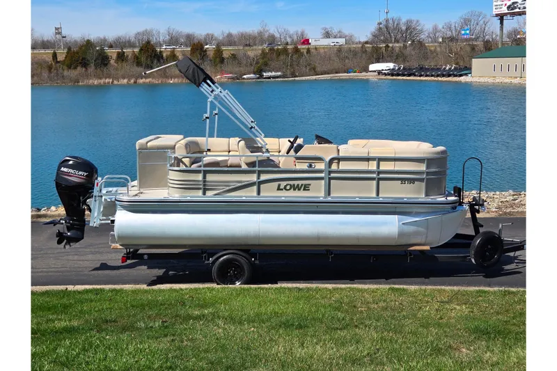 The Image of 2016 Lowe SS 190 pontoon boat on trailer by a lake. - 0