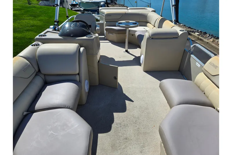 Slide: The Image of 2016 Lowe SS 190 pontoon boat interior with beige seating and lake view. - 10