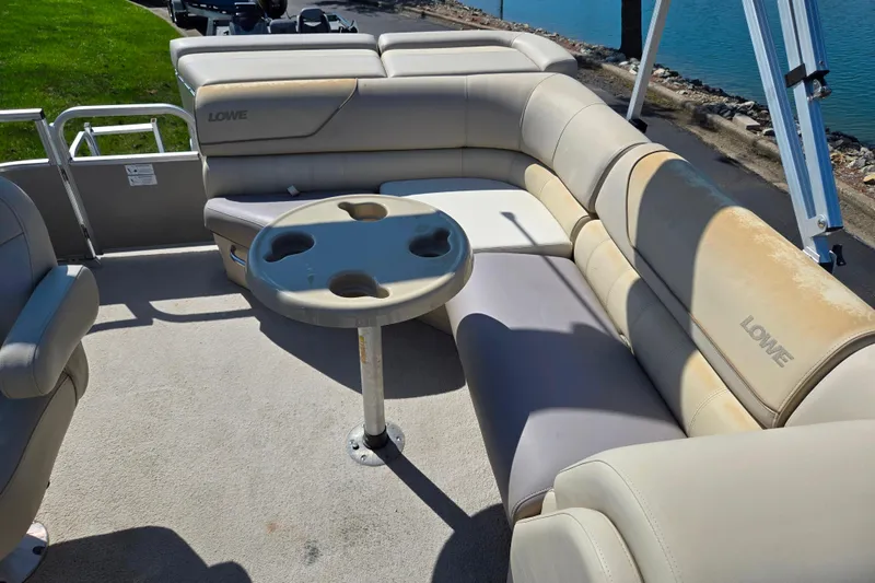 Slide: The Image of 2016 Lowe SS 190 pontoon boat interior with beige seating and cupholder table. - 13