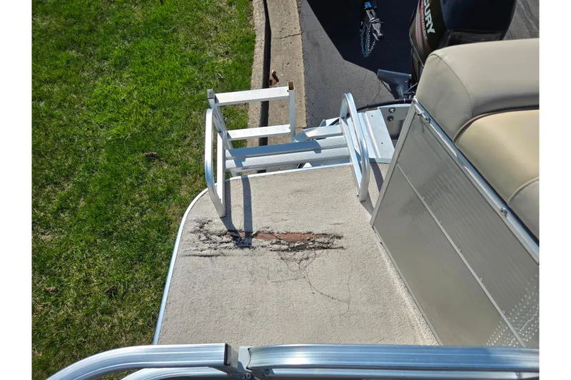 Slide: The Image of Damaged deck of 2016 Lowe SS 190 boat with metal railing and grass nearby. - 16