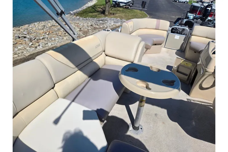 Slide: The Image of 2016 Lowe SS 190 pontoon boat interior with beige seating and cupholder table. - 19