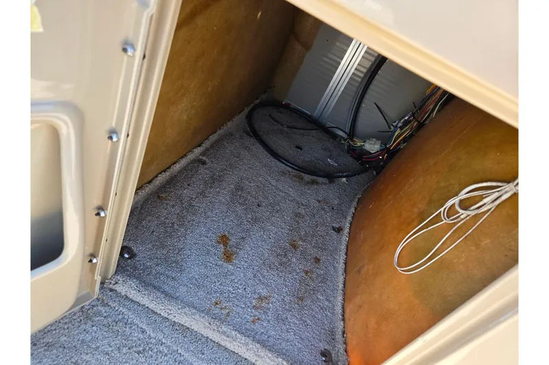 Slide: The Image of Interior storage compartment of a 2016 Lowe SS 190 boat, showing wiring and carpeted floor. - 22