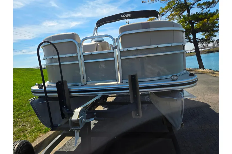Slide: The Image of 2016 Lowe SS 190 pontoon boat on trailer by a lake. - 6