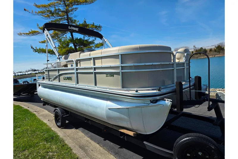 Slide: The Image of 2016 Lowe SS 190 pontoon boat on trailer by a lake. - 8
