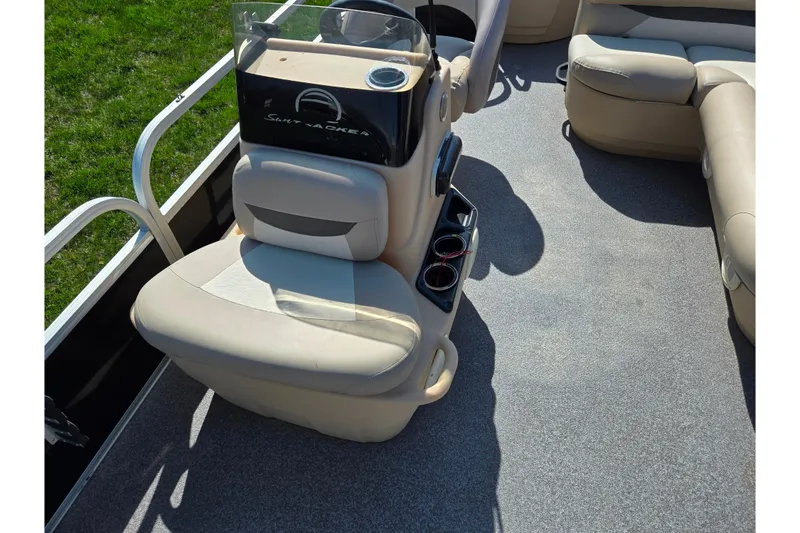 Slide: The Image of 2016 Sun Tracker Bass Buggy 18 DLX interior with beige seating and steering console. - 13