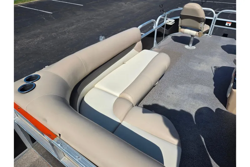 Slide: The Image of 2016 Sun Tracker Bass Buggy 18 DLX pontoon boat interior with beige seating and cup holders. - 22