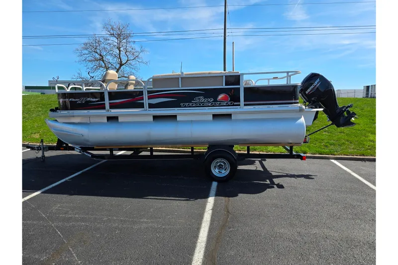 Slide: The Image of 2016 Sun Tracker Bass Buggy 18 DLX pontoon boat on trailer in parking lot. - 4