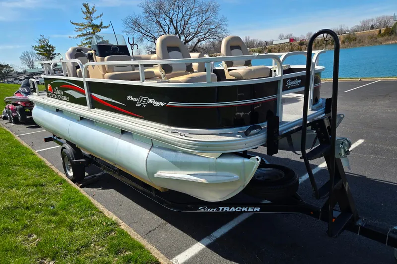 Slide: The Image of 2016 Sun Tracker Bass Buggy 18 DLX pontoon boat on trailer by a lake. - 8