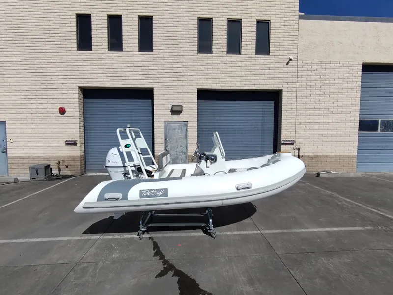 Slide: The Image of 2025 Tide Craft San Juan 11 boat on trailer, parked outside industrial building. - 1