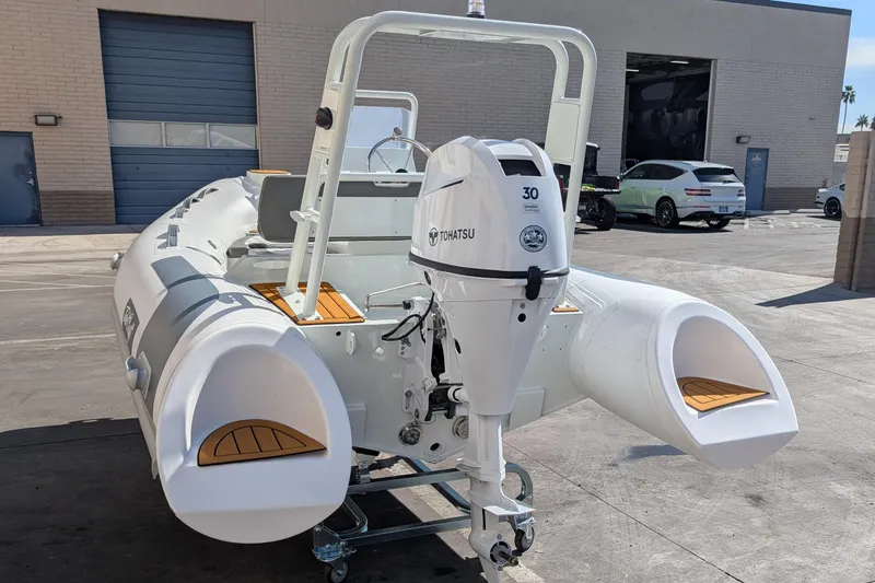 Slide: The Image of 2025 Tide Craft San Juan 11 inflatable boat with Tohatsu outboard motor in a garage setting. - 3