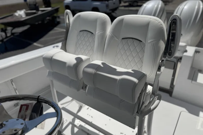 Slide: The Image of 2026 Sportsman Open 252 Center Console boat with luxurious white seating and steering wheel. - 13