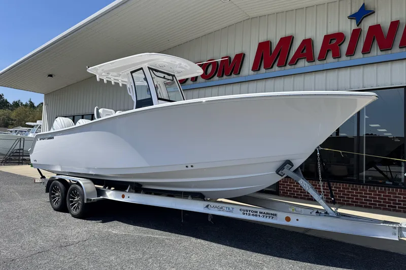 Slide: The Image of 2026 Sportsman Open 252 Center Console boat on trailer outside marine store. - 7