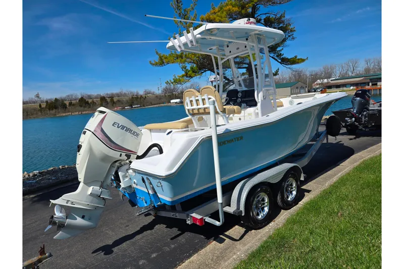 Slide: The Image of 2016 Tidewater 220 LXF boat with Evinrude motor on trailer by a lake. - 1