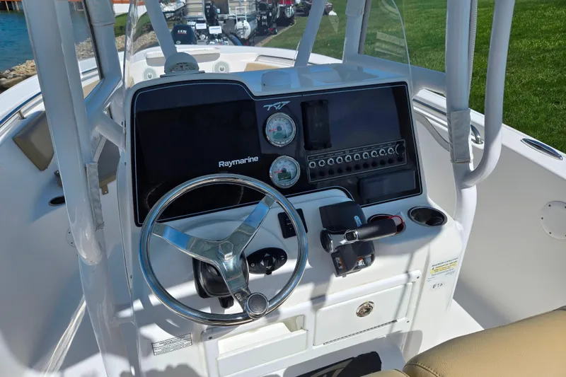 Slide: The Image of 2016 Tidewater 220 LXF boat dashboard with steering wheel and Raymarine electronics. - 12