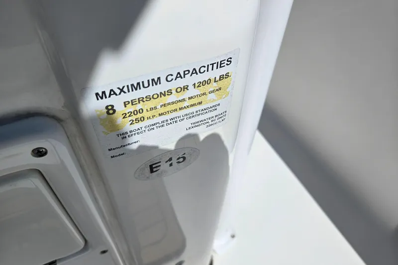 Slide: The Image of Maximum capacity label on 2016 Tidewater 220 LXF boat, showing weight and passenger limits. - 13